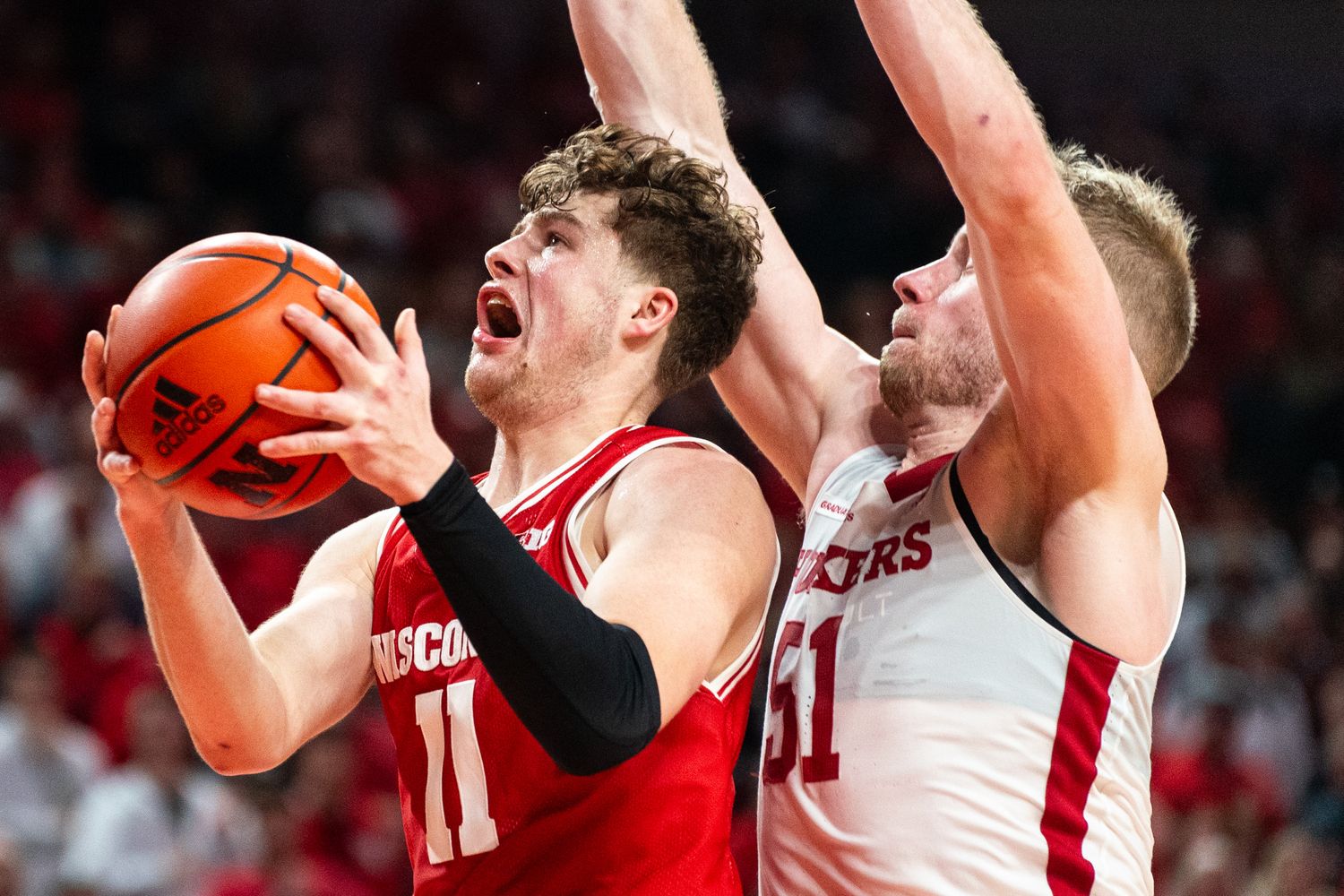 Feb 1, 2024; Lincoln, Nebraska, USA; Wisconsin Badgers guard Max Klesmit (11) drives against Nebraska Cornhuskers forward Rienk Mast (51) during overtime at Pinnacle Bank Arena.